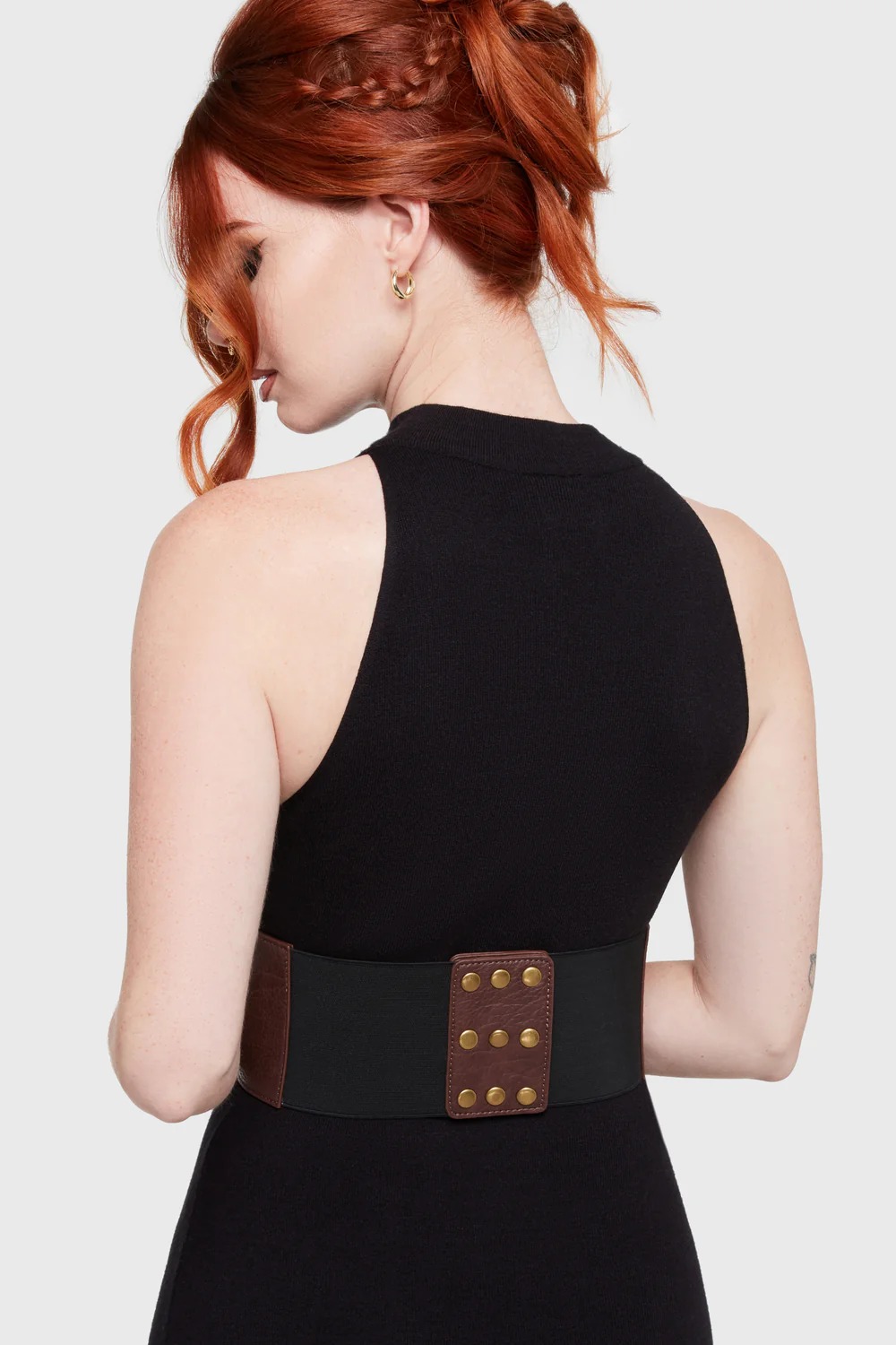 Close-up of brass gold hardware and velvet ribbon lacing on a vegan leather underbust corset.